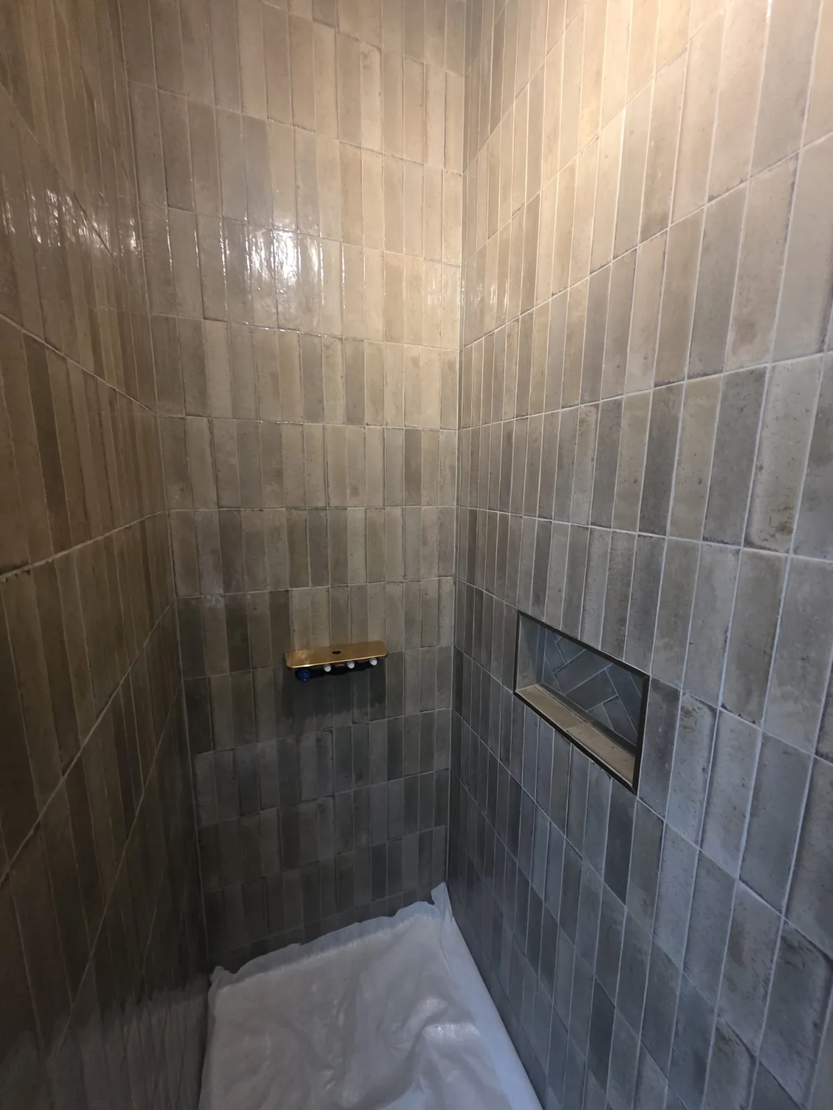 Douche carrelée en zellige avec niche décorative et robinetterie laiton, réalisée par AS de Bâtiment sur le Bassin d'Arcachon