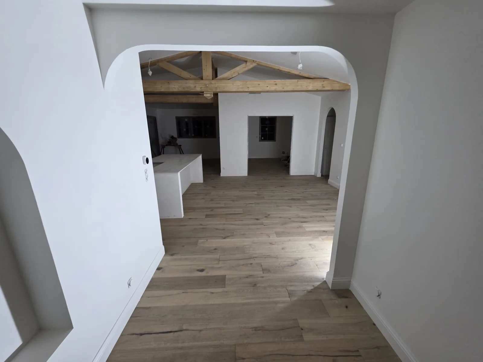 Rénovation intérieure avec arches et poutres apparentes