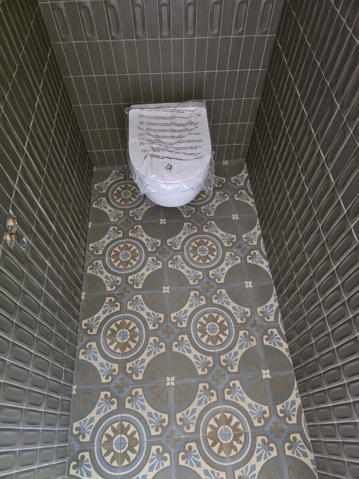 WC suspendu avec carrelage relief et sol en carreaux de ciment posés par AS de Bâtiment